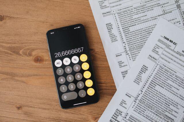 UAE VAT calculator on phone with tax documents